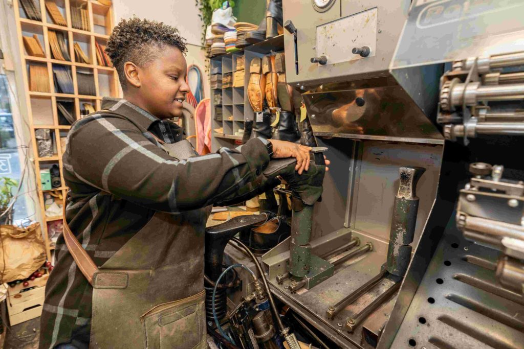 Vrouw houdt hak van een schoen bij machine | MBO Kompas 2026