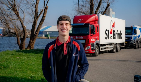 jongen met pet staat buiten voor vrachtwagen