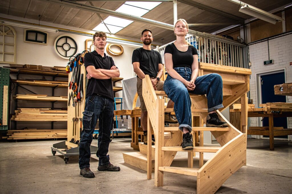 3 jonge mensen op installatie van hout