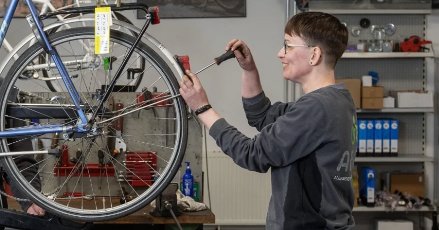 vrouw sleutelt aan fiets