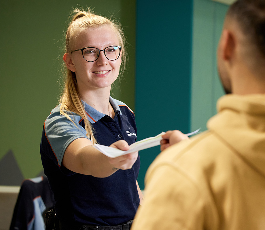 vrouw in DJI-uniform overhandigt papier aan iemand