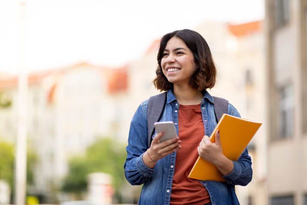 jonge vrouw met smartphone en map kijkt om zich heen