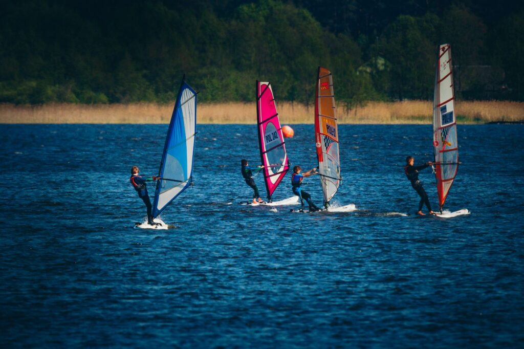 4 windsurfers varen over een meer | MBO Kompas